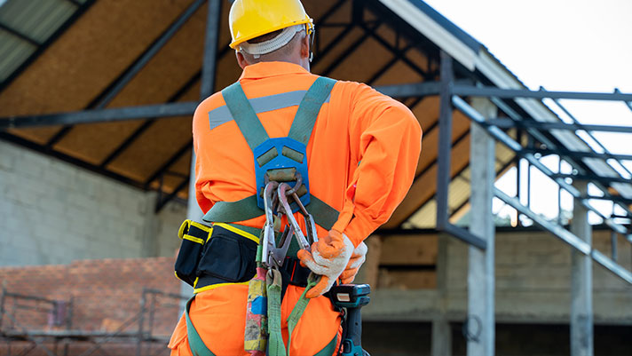 construction worker with hard hat and safety harness