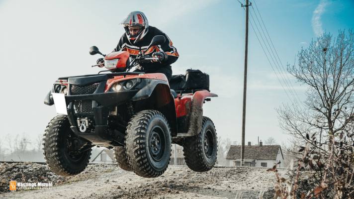 Man driving all terrain vehicle: drive your ATV safely.
