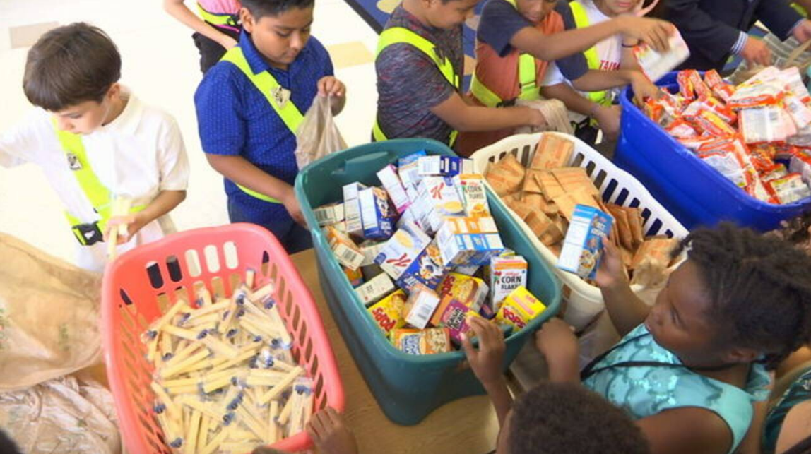 children filling bags at Blessings in a Backpack charity event