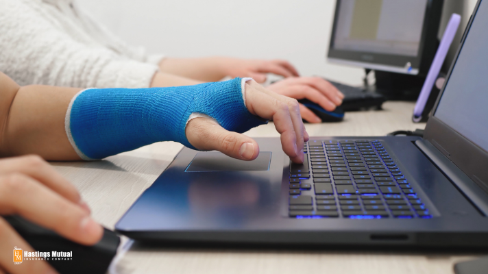 arm in cast typing on laptop computer