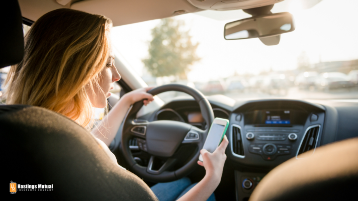 Young woman texting while driving: eyes on the road!