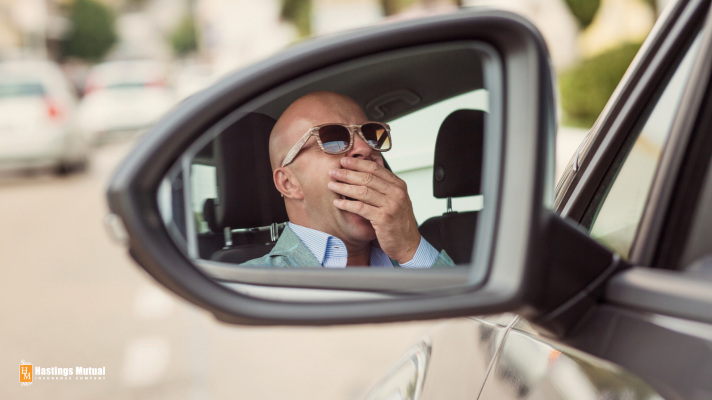 Man yawning in car: either take a nap or drive your car, not both.